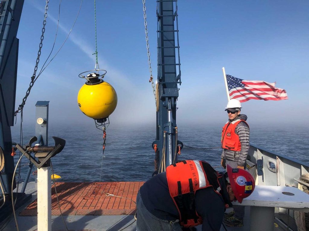 : Image courtesy of researcher Jay Austin. Technician Craig Hill and Marine Tech Jason Agnich prepare to deploy an acoustic current meter in Lake Superior; the data is stored in the Data Repository for University of Minnesota (DRUM).