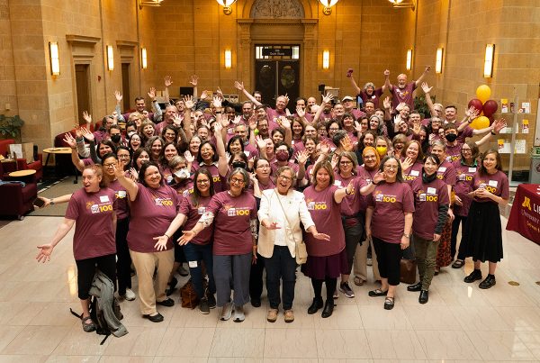 Group portrait of all the attendees wearing identical maroon T-shirts at the Walter Library at 100: An Afternoon Tea celebration