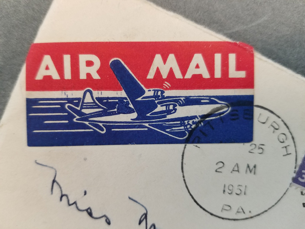 An air mail graphic mark, featuring an illustration of an airplane, on an envelope from the Social Welfare History Archives
