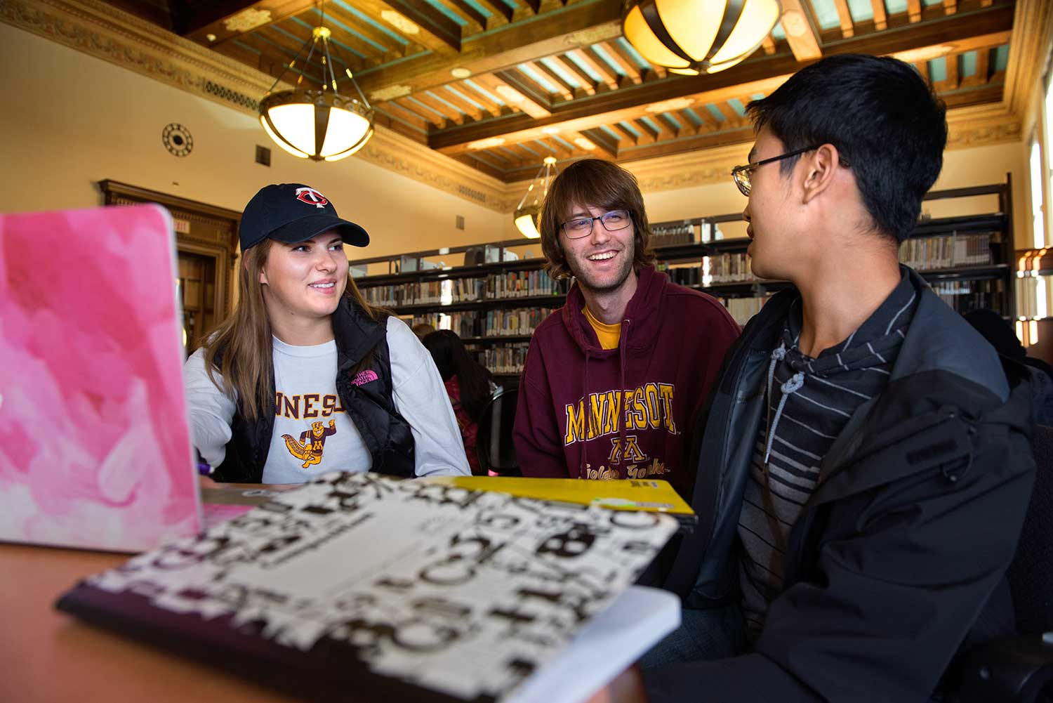 Three students studying in Walter Library's South Reading Room.