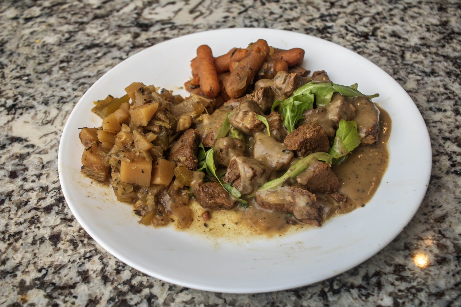 The final product: stewed beef and arugula, covered in gravy, with potatoes, parsnips, and carrots on the side.