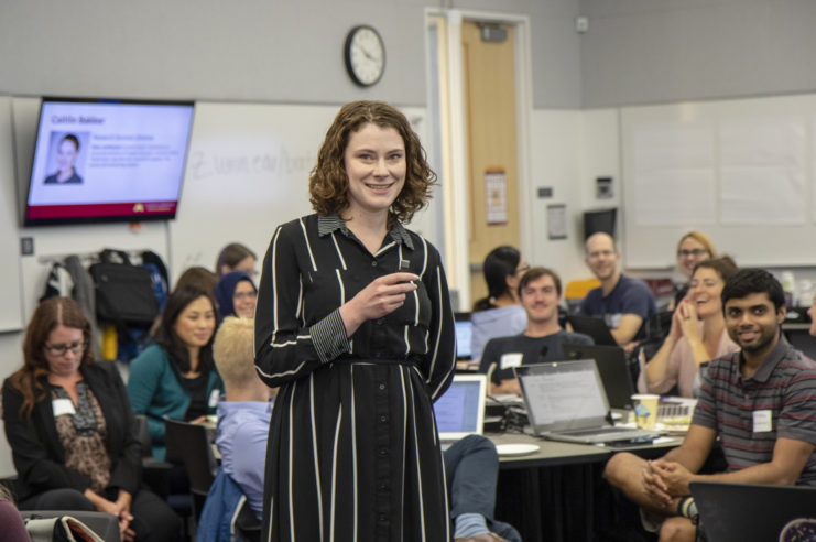 Librarian Caitlin Bakker smiles after telling a humorous story during her presentation at Data Management Boot Camp. Students in the background are laughing.