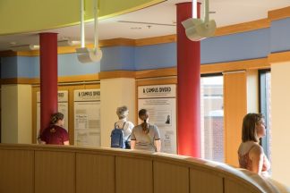 Exhibit visitors looking at the exhibit panels in Andersen Library.