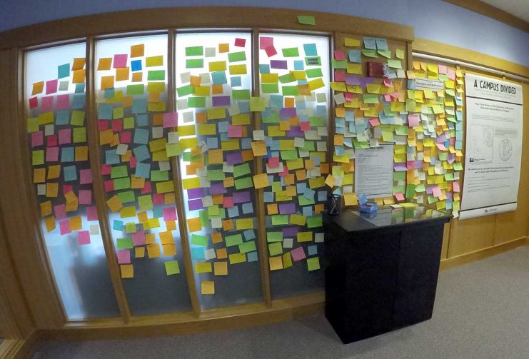 Post-it Notes on the wall commenting on the Campus Divided Exhibit