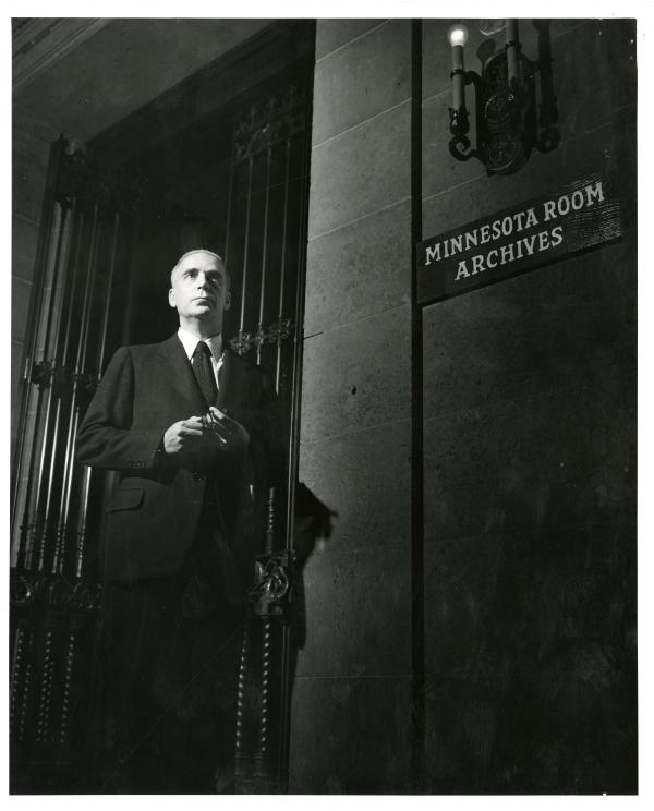 James Gray, History department faculty member and author of the 1951 centennial history of the University of Minnesota outside the archives room in Walter Library, 1949.