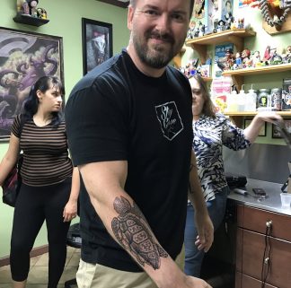 Jason Herbert with turtle tattoo on forearm