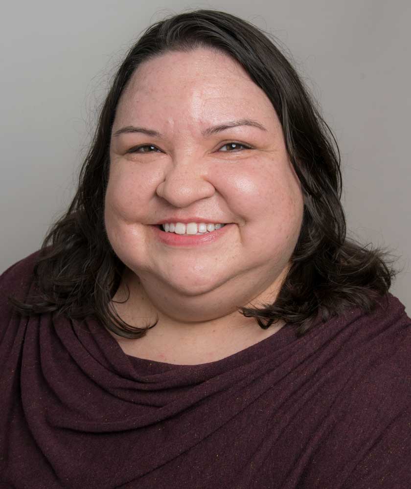 Headshot of smiling librarian wearing a maroon blouse