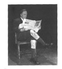 Man wearing prosthetic legs reading newspaper.