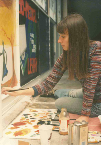 Student paints the bridge next to the panel for the Bio-Medical Library. Image circa 1990s courtesy of the University Archives.