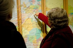 People using the map in the "People on the Move" exhibit to mark the journey of their families.