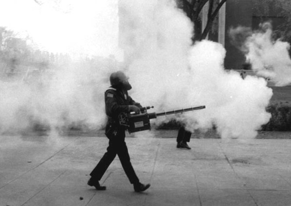 Police wearing gas masks walk through campus, attempting to disperse the crowds. University of Minnesota Archives Photograph Collection. Available at http://purl.umn.edu/71641