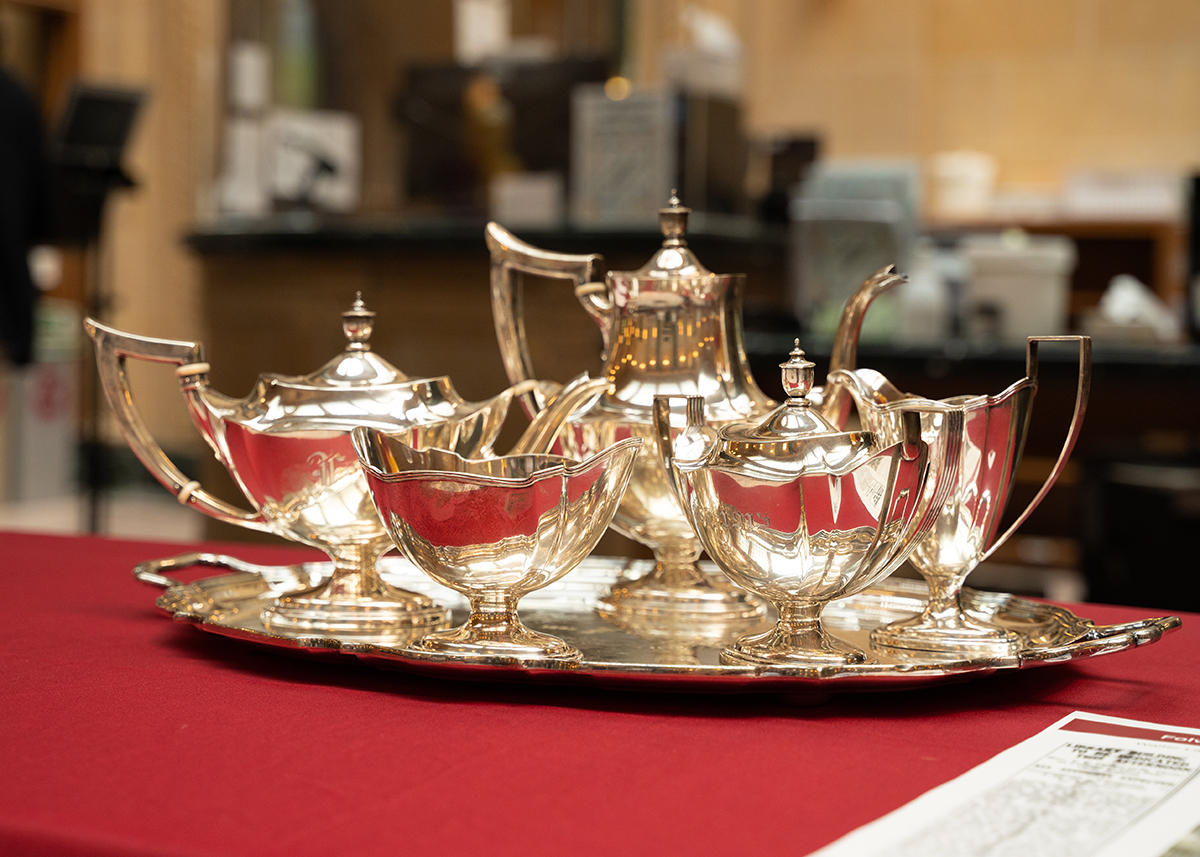 A burnished silver tea set rests atop a silver platter