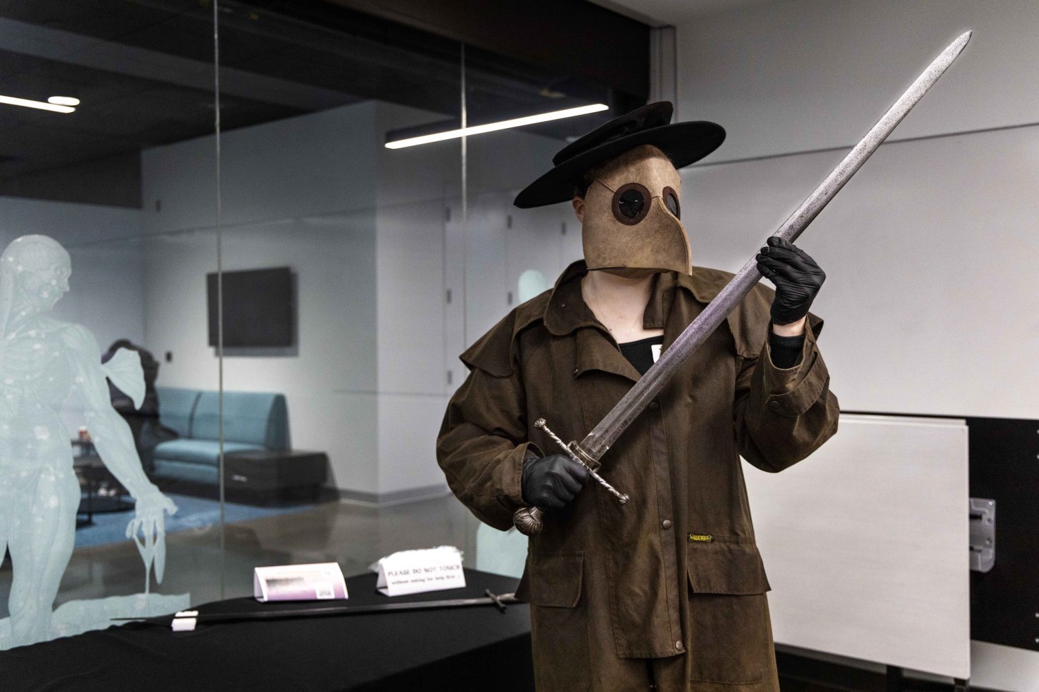 WHL's plague doctor wields an antique sword at the Wangensteen pop-up exhibit.