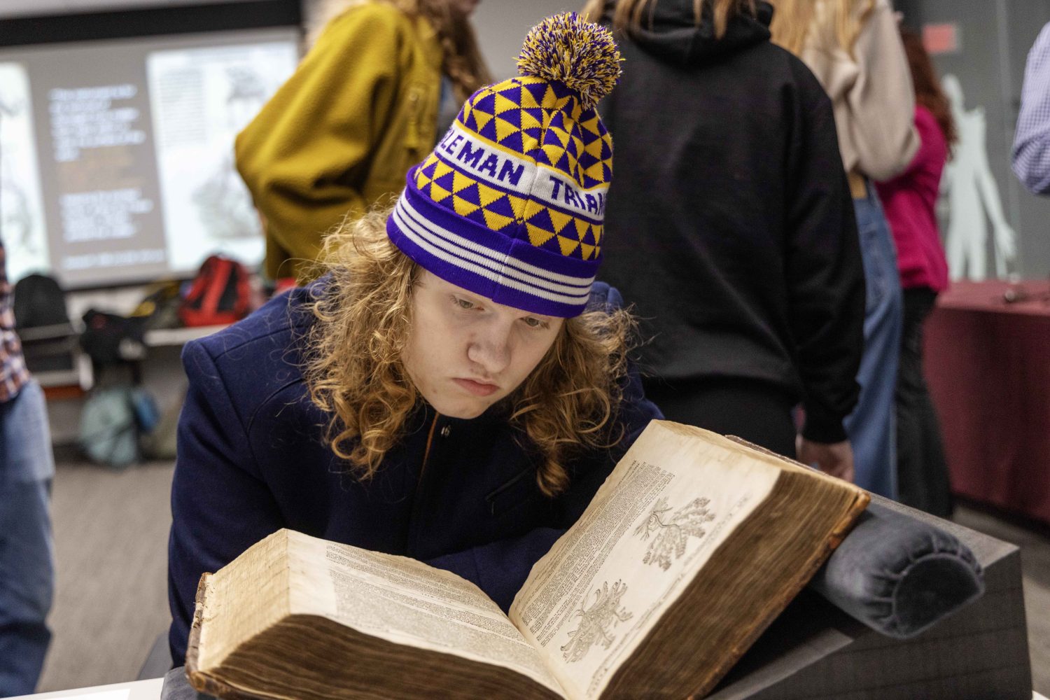 A student reads a rare book at the Wangensteen pop-up exhibit.