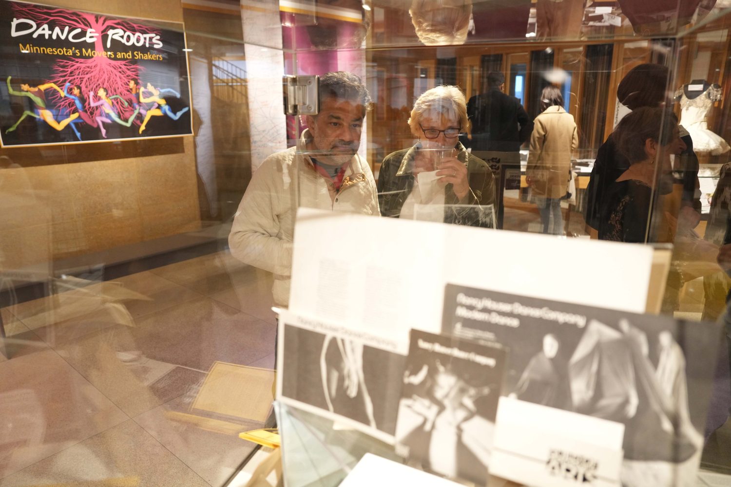 Attendees browse the display cases at the opening of PAA's "Dance Roots" exhibit, on Oct. 27, 2023. Exhibit designed by Darren Terpstra. (Photo/Luke Logan)