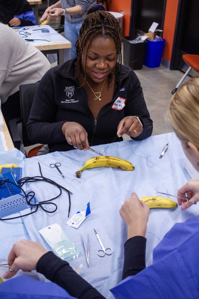 Students learn the techniques behind stitching and practice on a banana, on Saturday, Oct. 28, 2023. (Photo/Adria Carpenter)