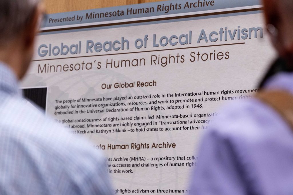 Attendees walk through the Minnesota Human Rights Archive's inaugural exhibit, "The Global Reach of Local Activism: Minnesota’s Human Rights Stories," on Thursday, February 8, 2024, in Elmer L. Andersen Library. (Photo/Adria Carpenter)