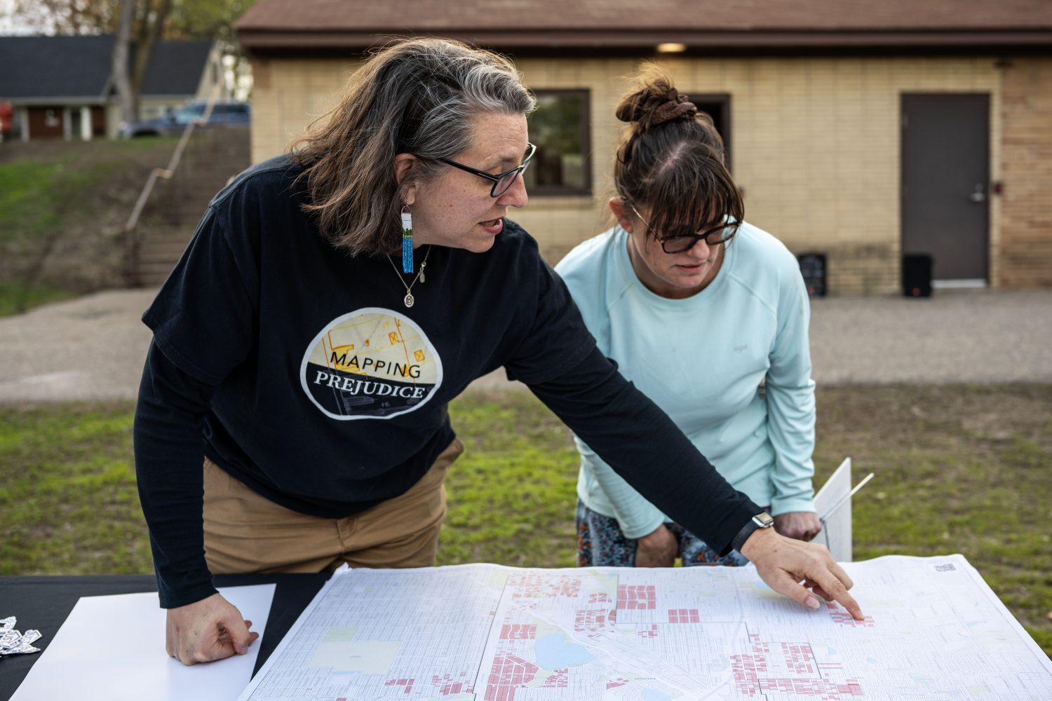 Julliette Dannucci learns about the racial covenant on her home with Rebecca Gillette, the Mapping Prejudice community engagement lead, at Sanborn Park in Robbinsdale, Minnesota, on Friday, May 3, 2024. (Photo/Adria Carpenter)