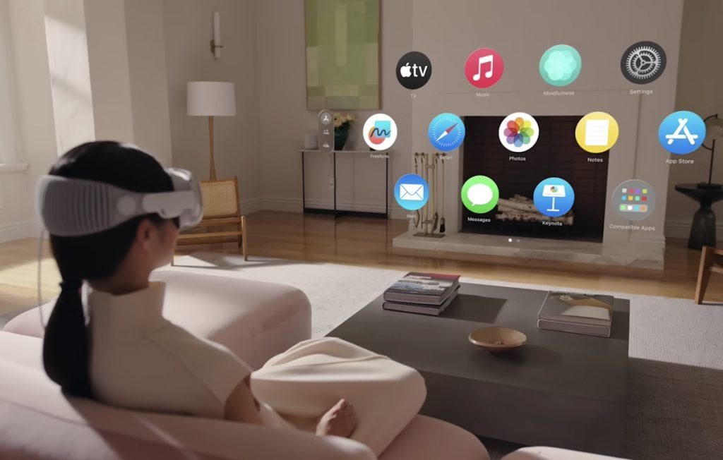 Person wearing a virtual reality headset in a living room. App icons are superimposed in the air in front of them.