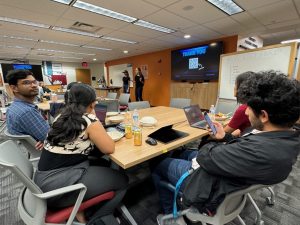 Two females present to the BASE participants in the Ideation Hub of the Toaster