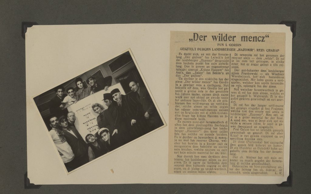 Scrapbook page with image of the entire “Hazomir” theater troupe posing in front of a sign for their production of “Der Wilder Mencz” (The Unusual Person), with accompanying newspaper article about the production in Yiddish at right. Eugenia Lewin/Jeanette Frank pictured middle-row center. Source: Jeanette and Kenneth Frank Papers, Upper Midwest Jewish Archives.