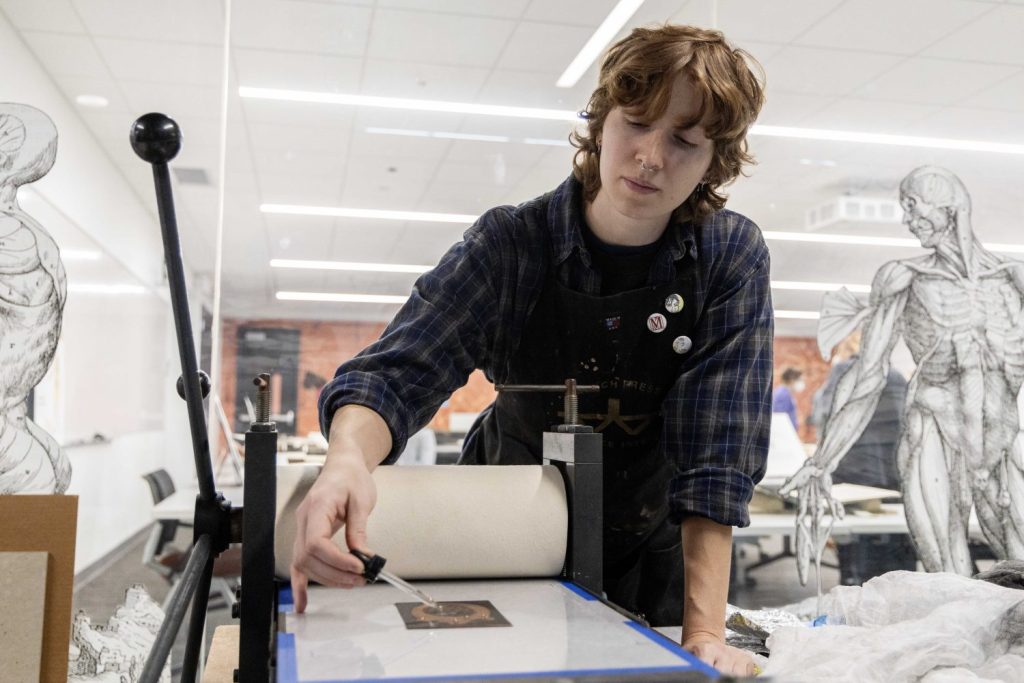 Sydney Petersen, a printing assistant, demonstrates how prints are made at the Wangensteen Historical Library's exhibit "Disembodied Reembodied," on Thursday, October 24, 2024. (Photo/Adria Carpenter)