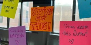 Post-it notes with words of encouragment placed on a window.