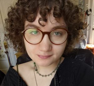 close up headshot of Sommer Wagen, with curly hair and glasses