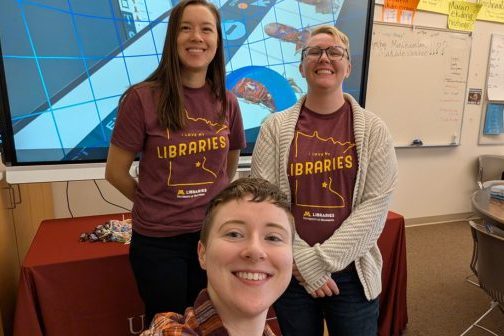 Three individuals in a classroom, posed in front of a screen showing virtual reality experiences.