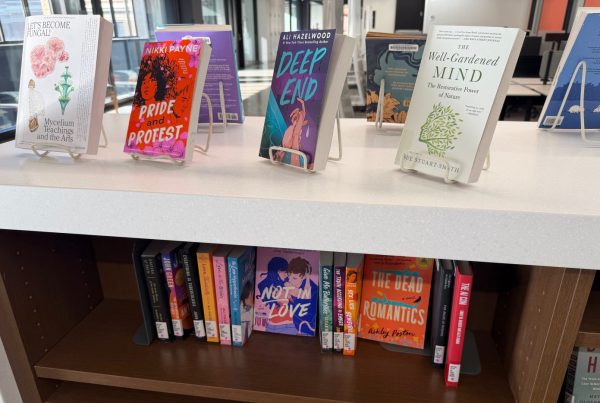 A collection of softcover books on a bookshelf are displayed for browsing.